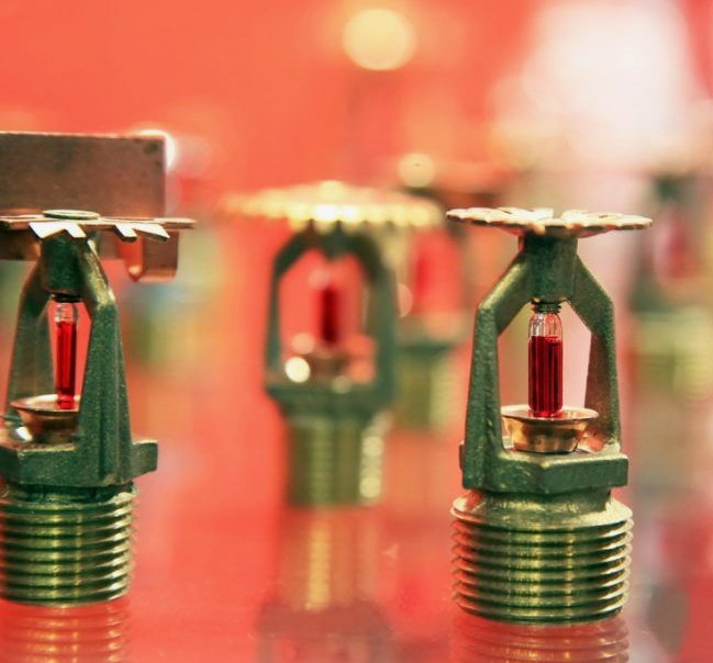 How do fire sprinklers effectively prevent the spread of fire?